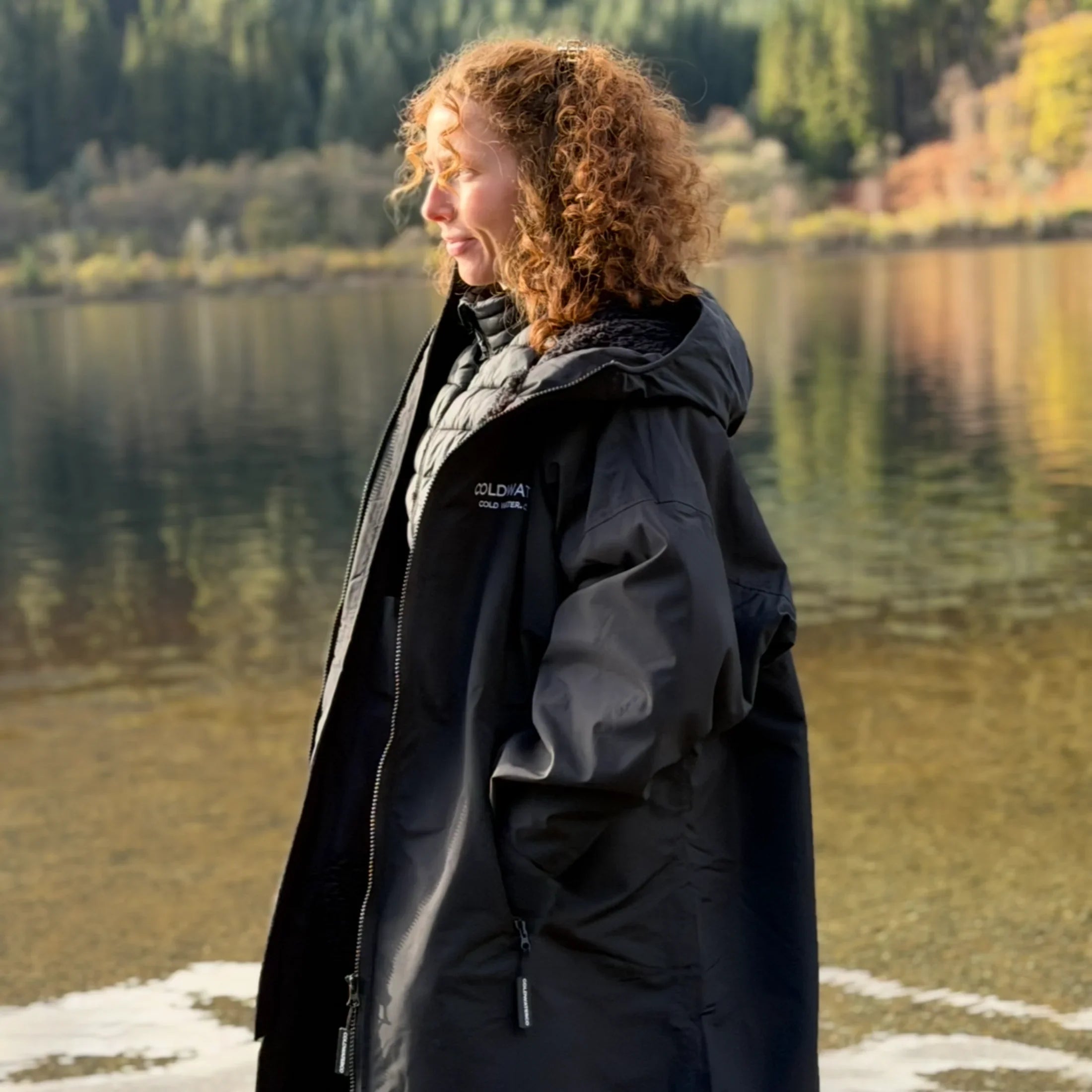 Woman wearing Coldwaterco changing robe near water