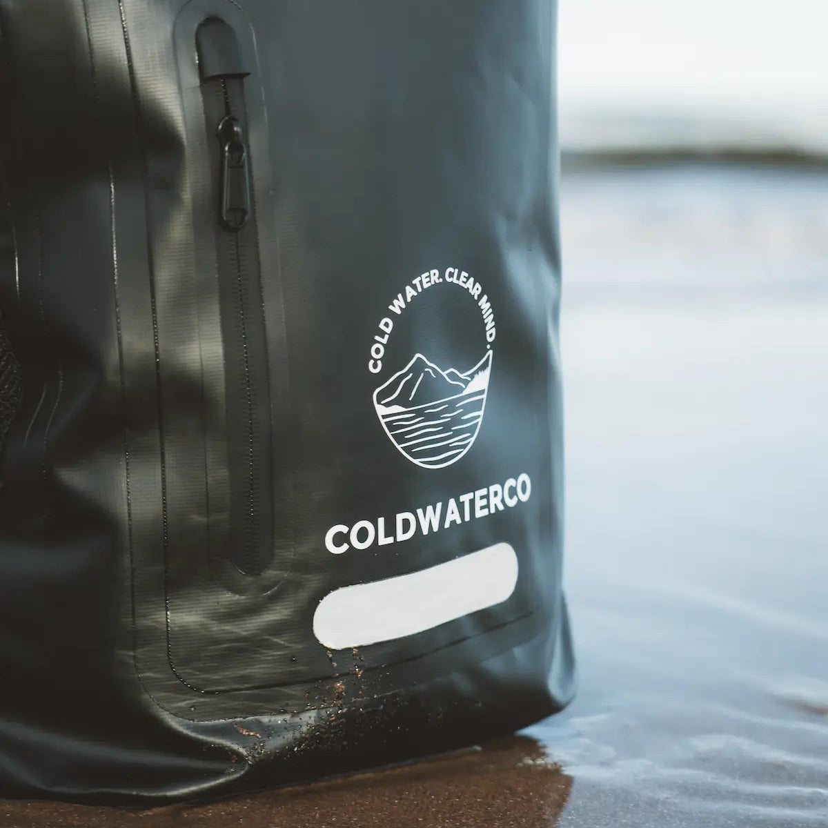 Black backpack with 'Coldwater Co' logo on a reflective surface