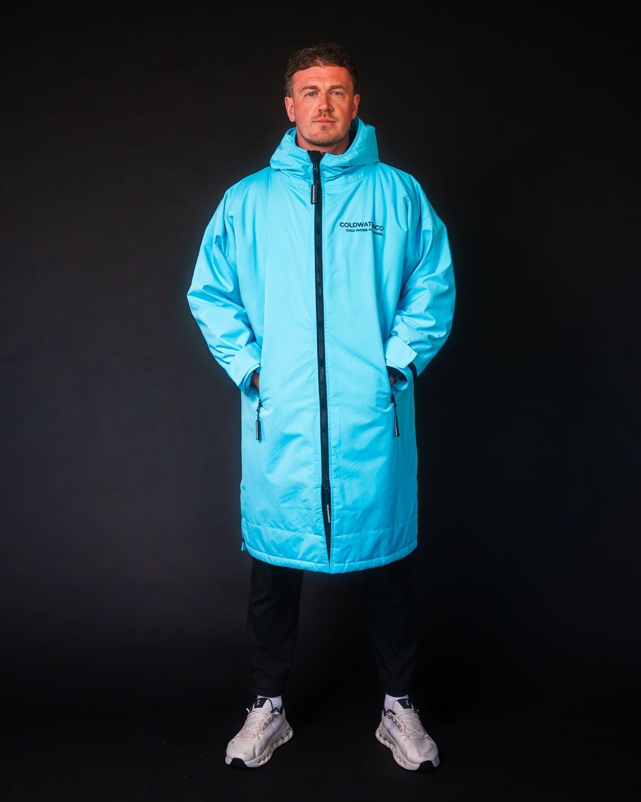 Person wearing a bright blue coat on a black background