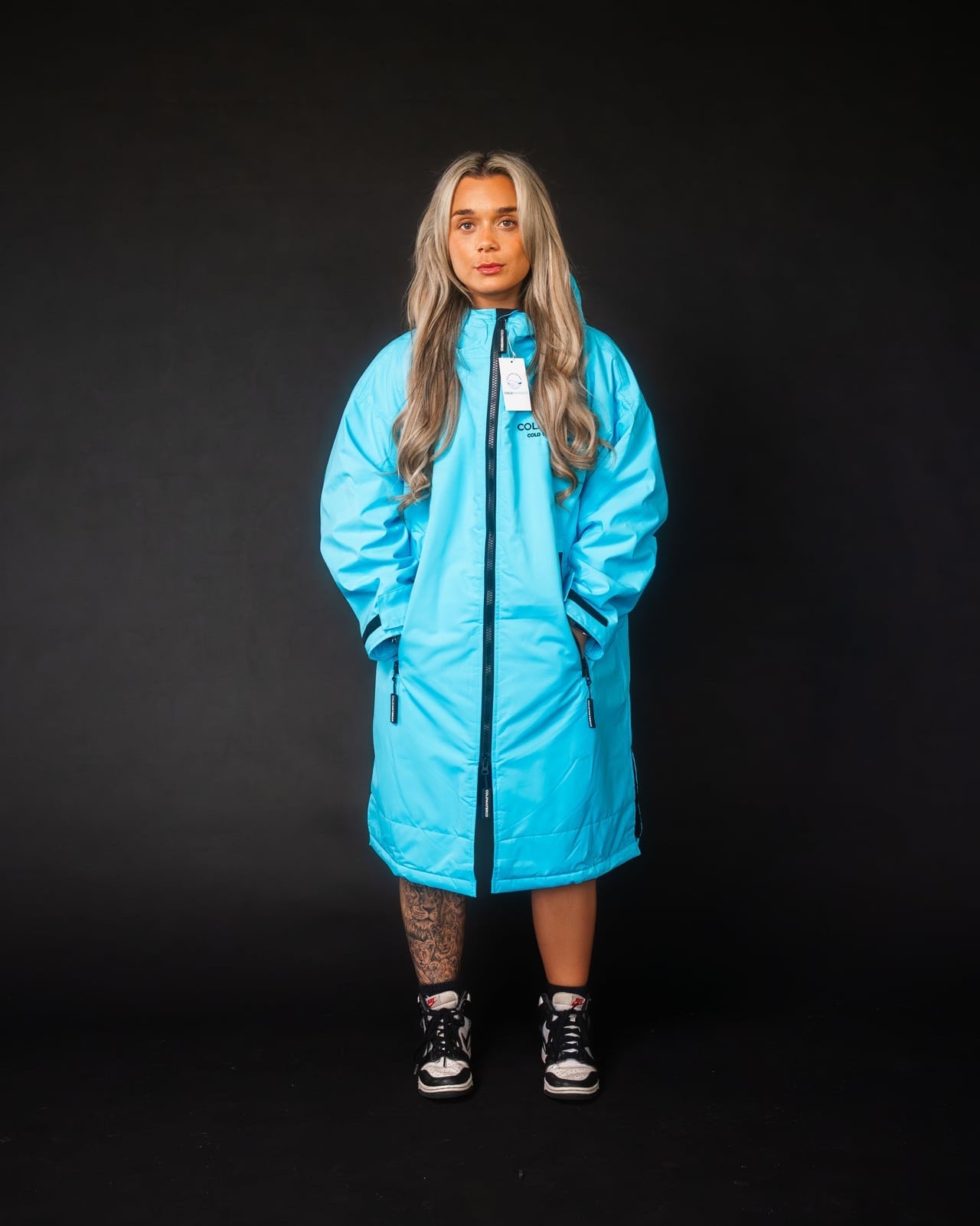 Person wearing a bright blue coat on a black background