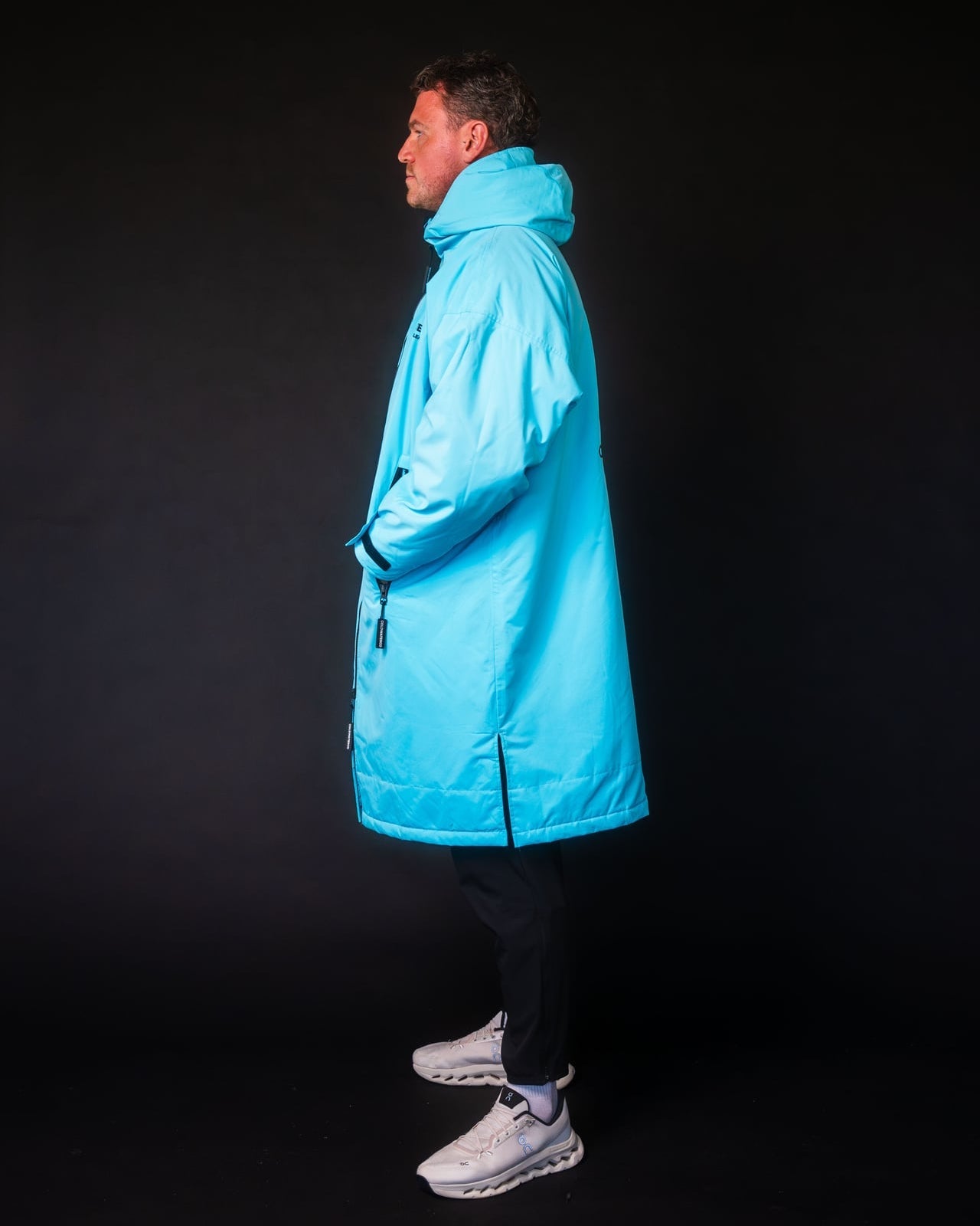 Person wearing a bright blue coat against a black background