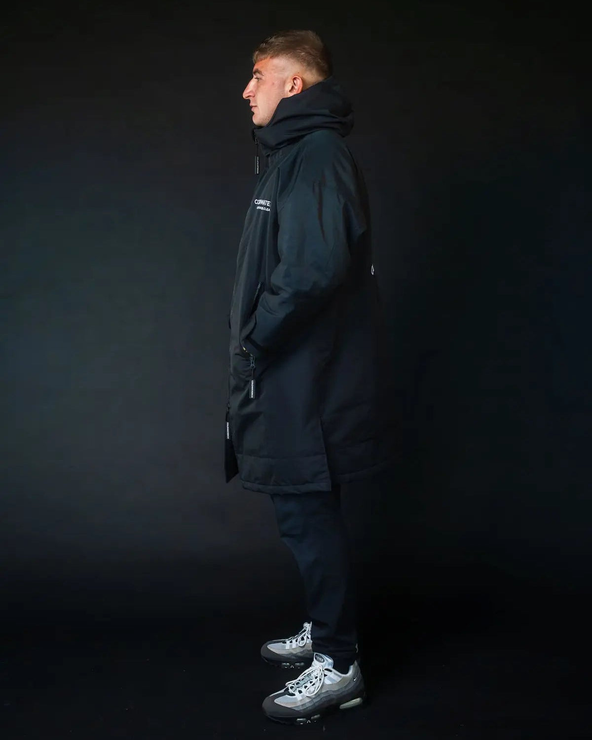 Man in black ColdWaterCo changing robe, studio photo
