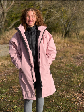 Woman in pink changing robe outdoors