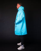 Person wearing a bright blue coat against a black background