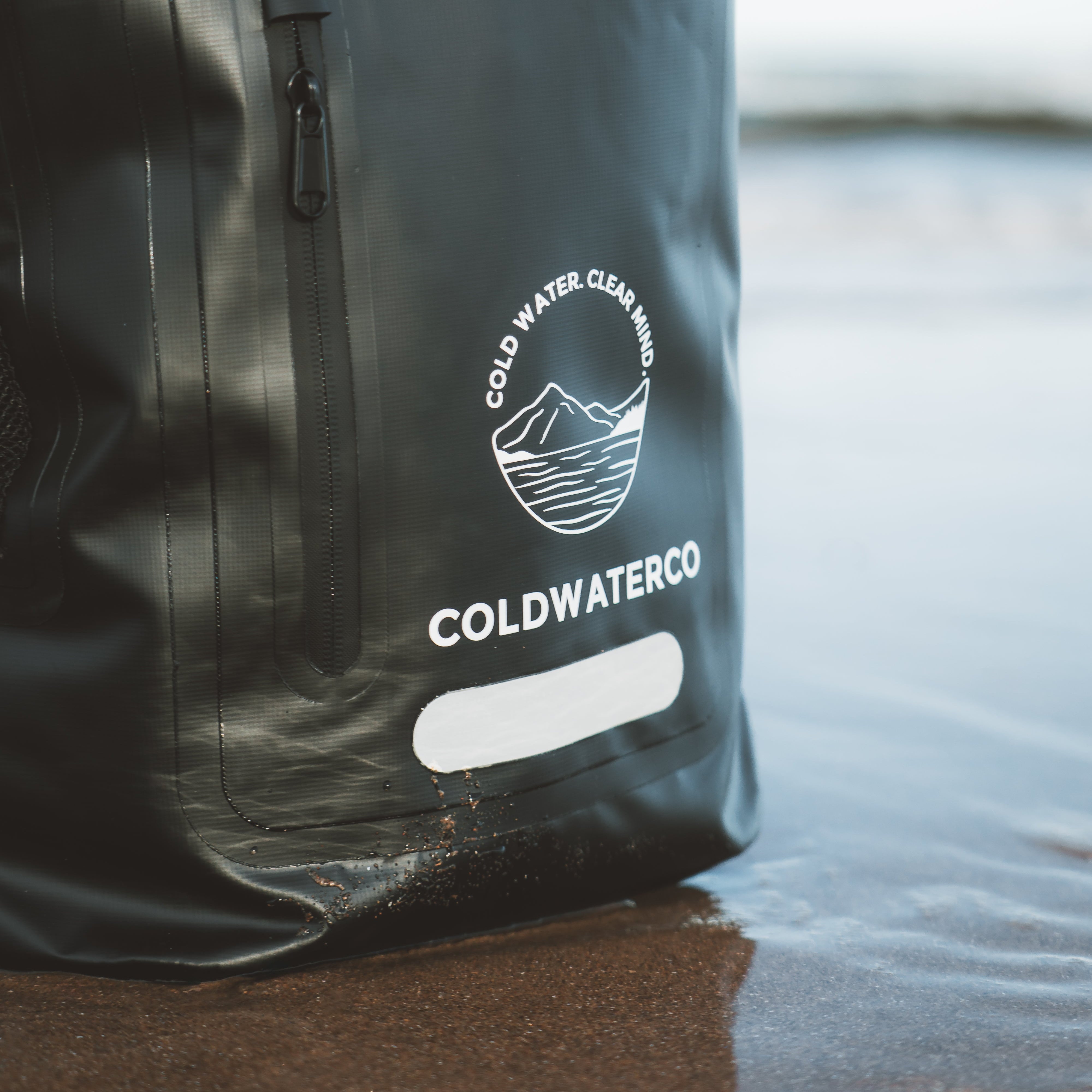 Black backpack with 'Coldwater Co' logo on a reflective surface