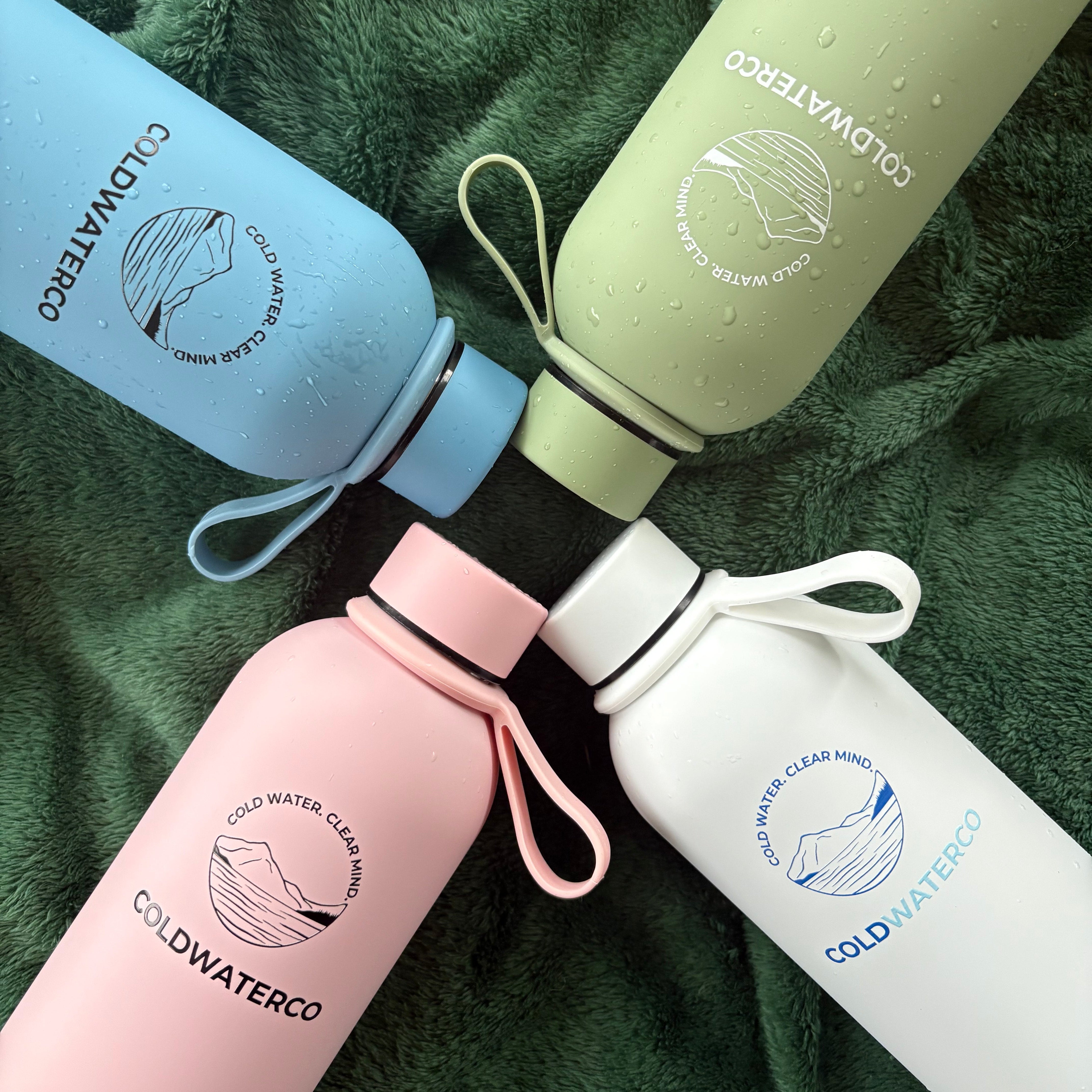 Four colorful water bottles with 'COLDWATERCO' branding on a green textured background.