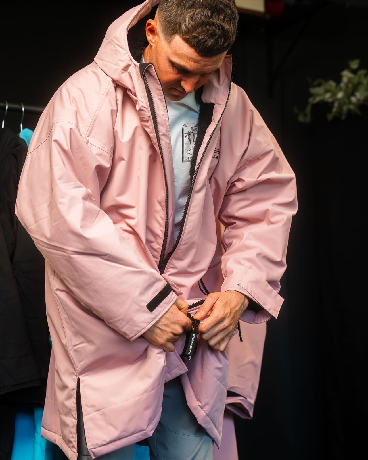Person wearing a pink coat with a dark background