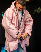 Person wearing a pink coat with a dark background