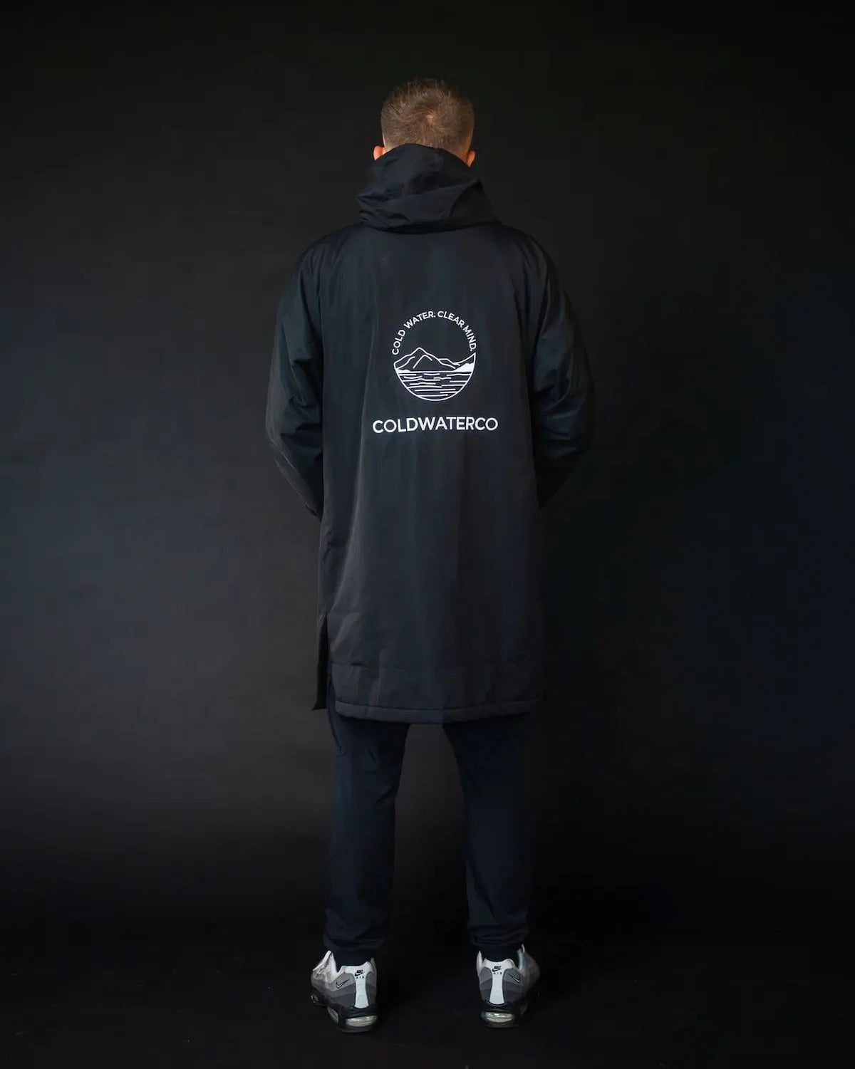 Man in black ColdWaterCo changing robe studio photo