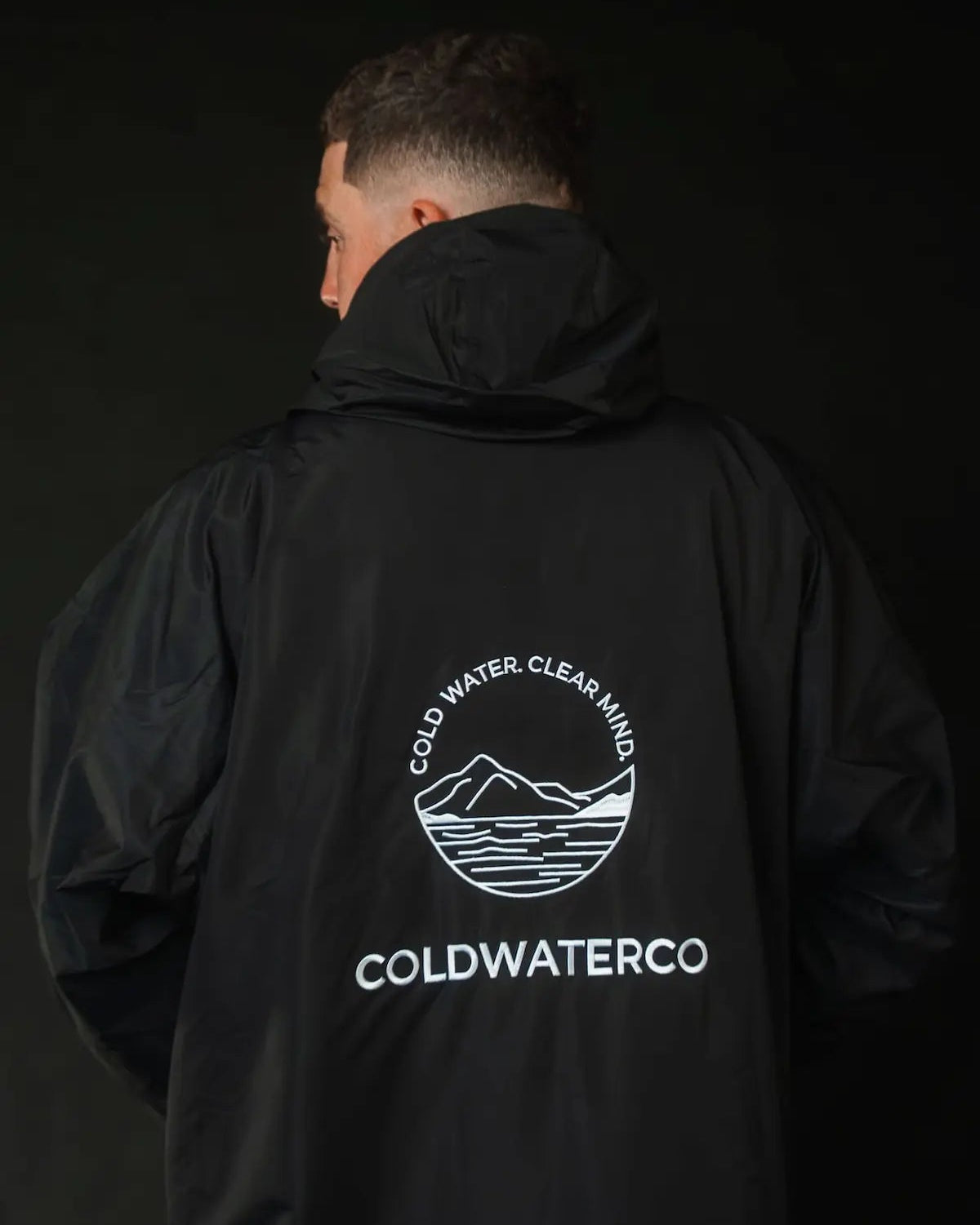 Man in pink ColdWaterCo changing robe, studio photograph