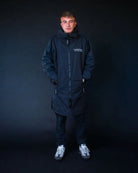 Man in black ColdWaterCo changing robe studio photo