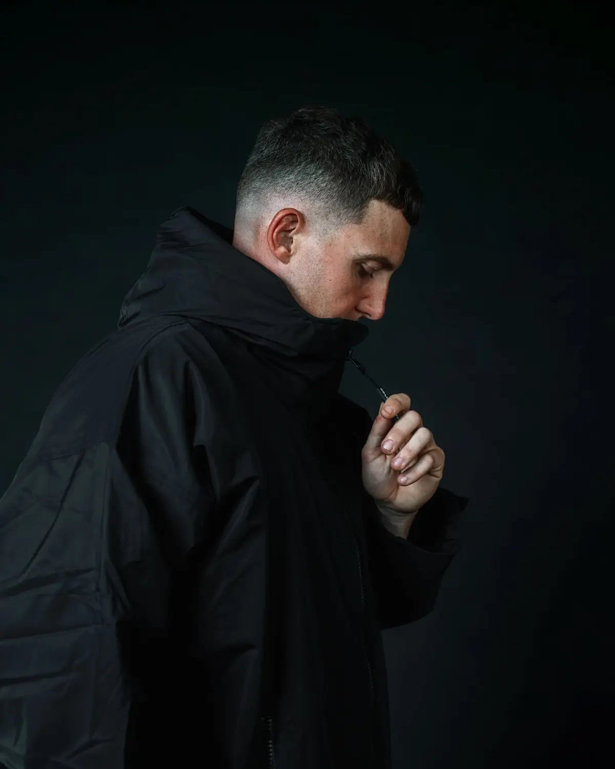 Man in black ColdWaterCo changing robe, studio photograph