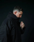 Man in black ColdWaterCo changing robe, studio photograph