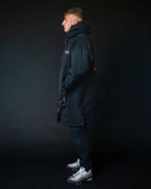 Man in black ColdWaterCo changing robe, studio photo