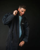 Man in black ColdWaterCo changing robe, studio photograph