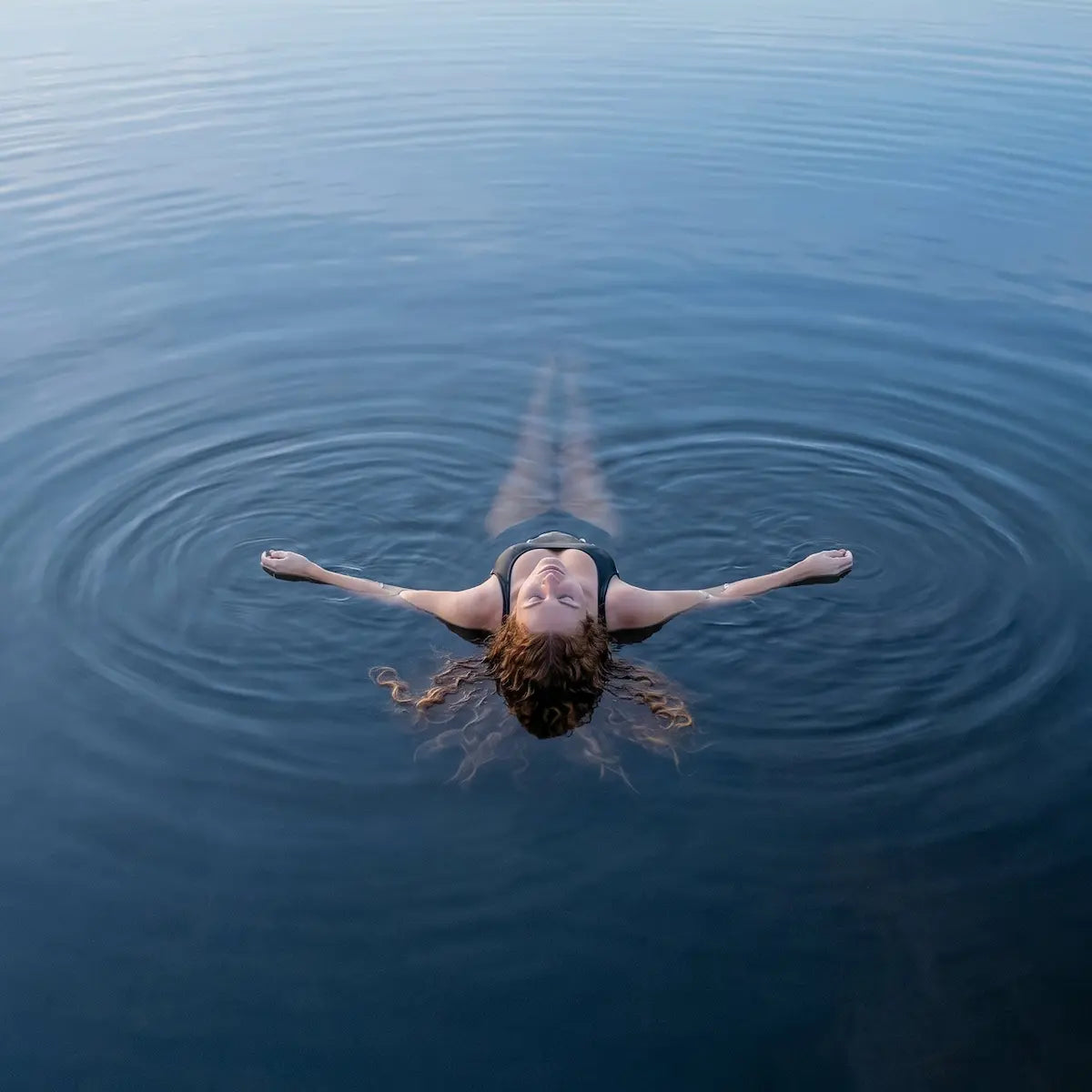 Person floating on water with minimal ripples